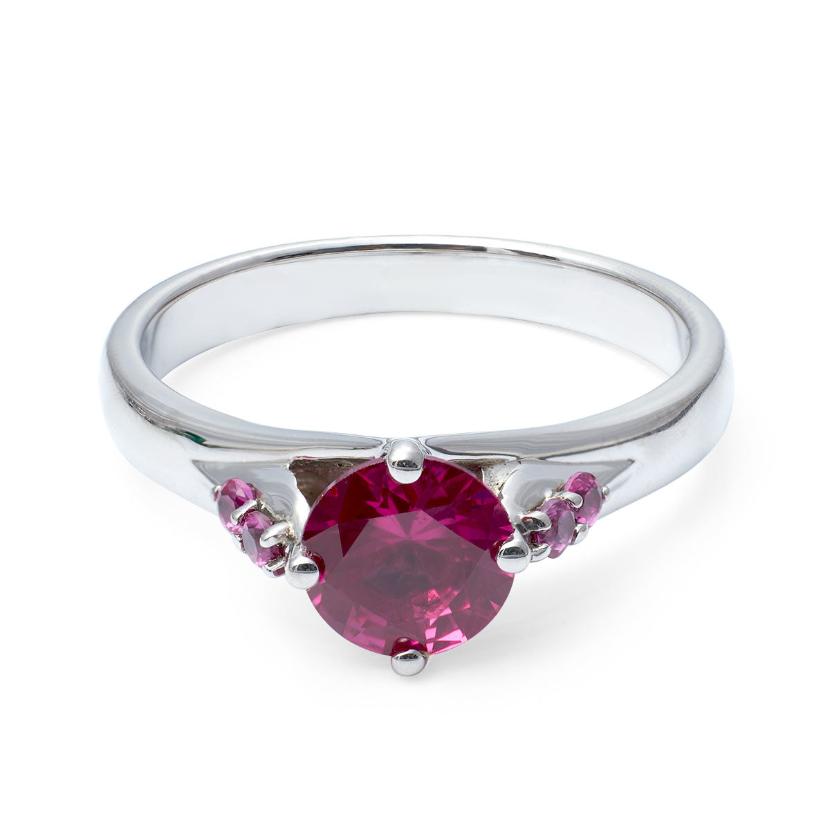 Minimalist promise ring featuring a bold, round pink sapphire-style stone and pink side stones.