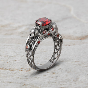 black skull ring with red garnet gemstones and criss cross mesh design band
