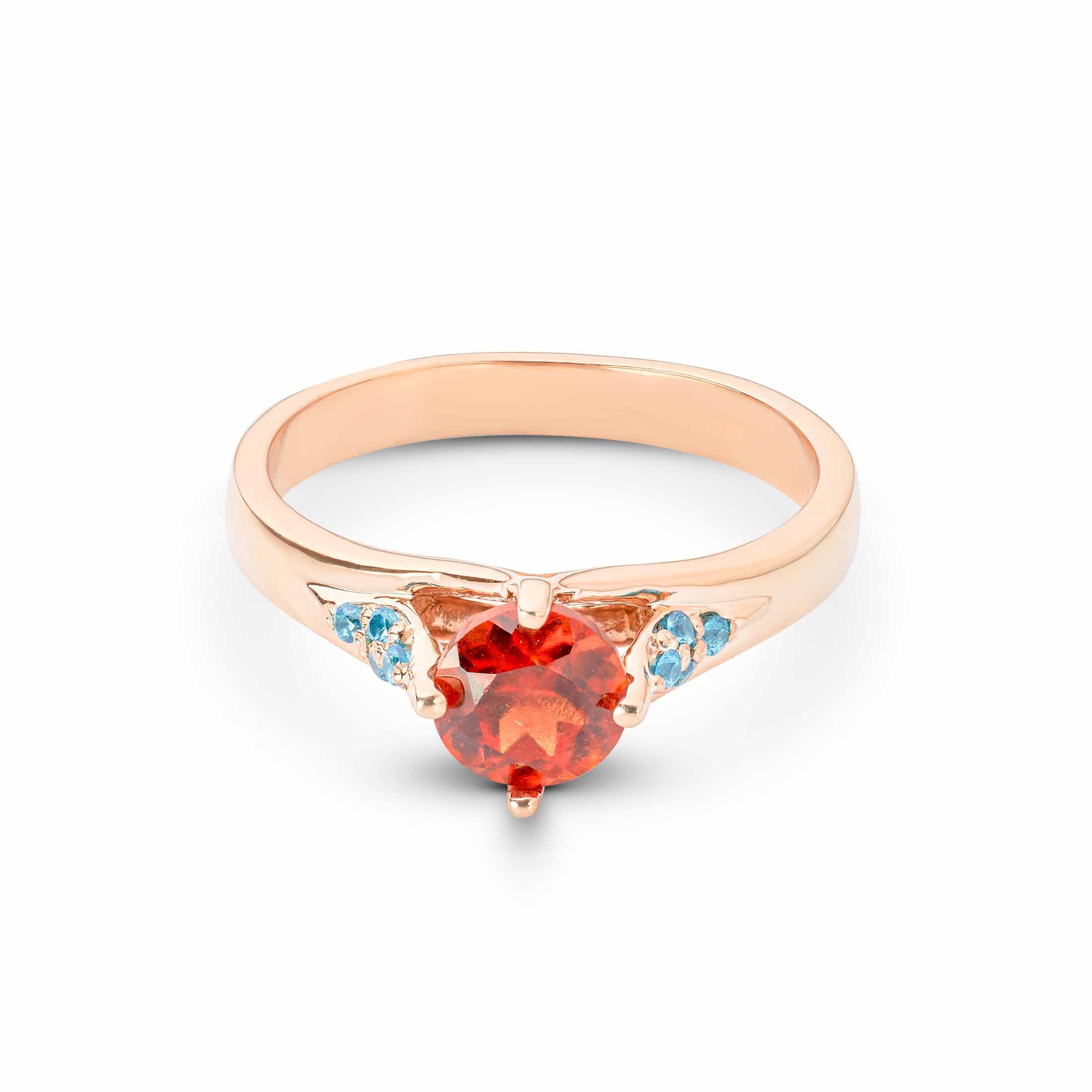 Cocktail Ring ring with a red gemstone and blue accents on a white background