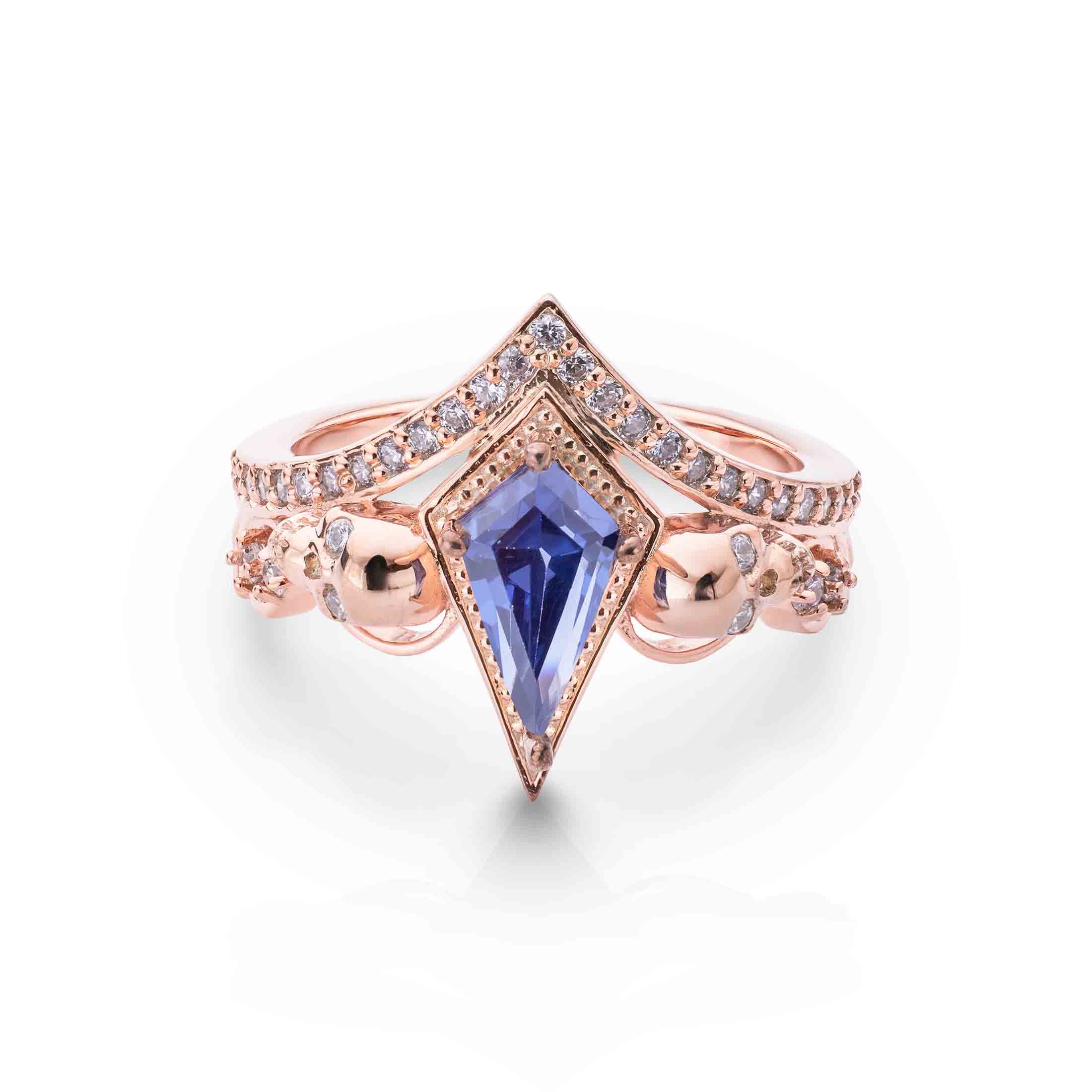Gothic inspired rose gold jewelry with a large kite-cut purple gemstone and intricate skull accents.