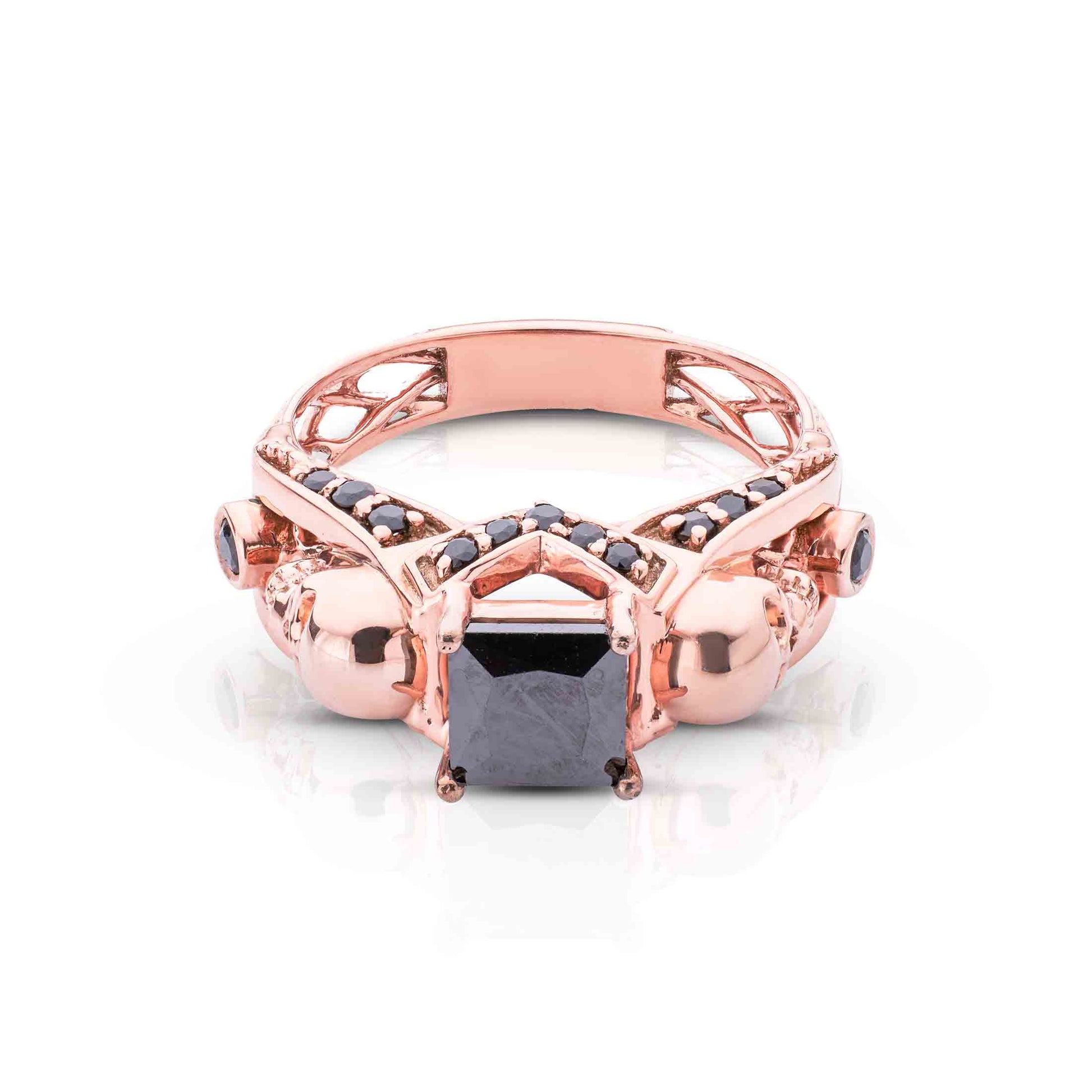 Rose gold ring with a black gemstone on a white background