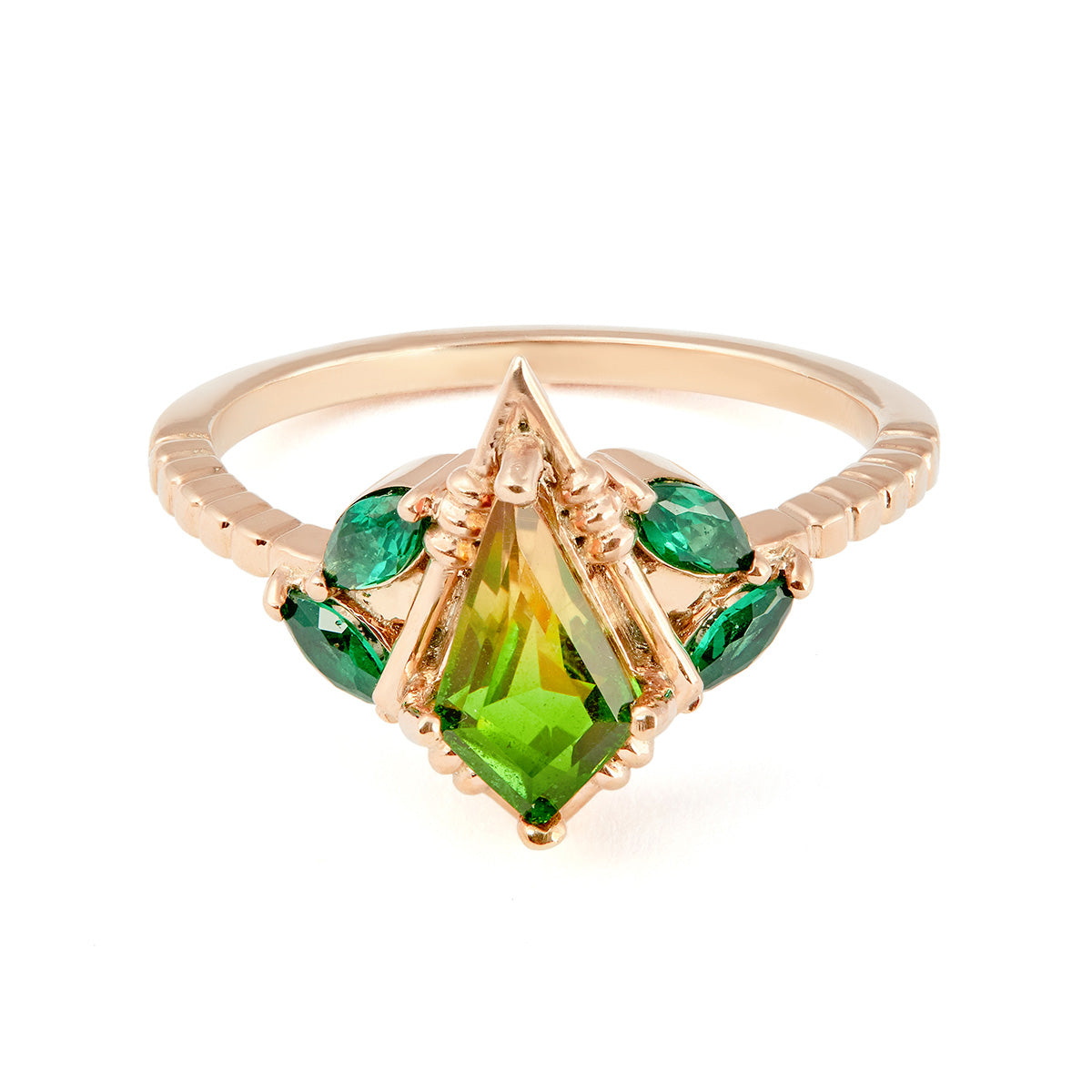 Kite-cut lime green peridot ring with emerald side stones and a textured band.