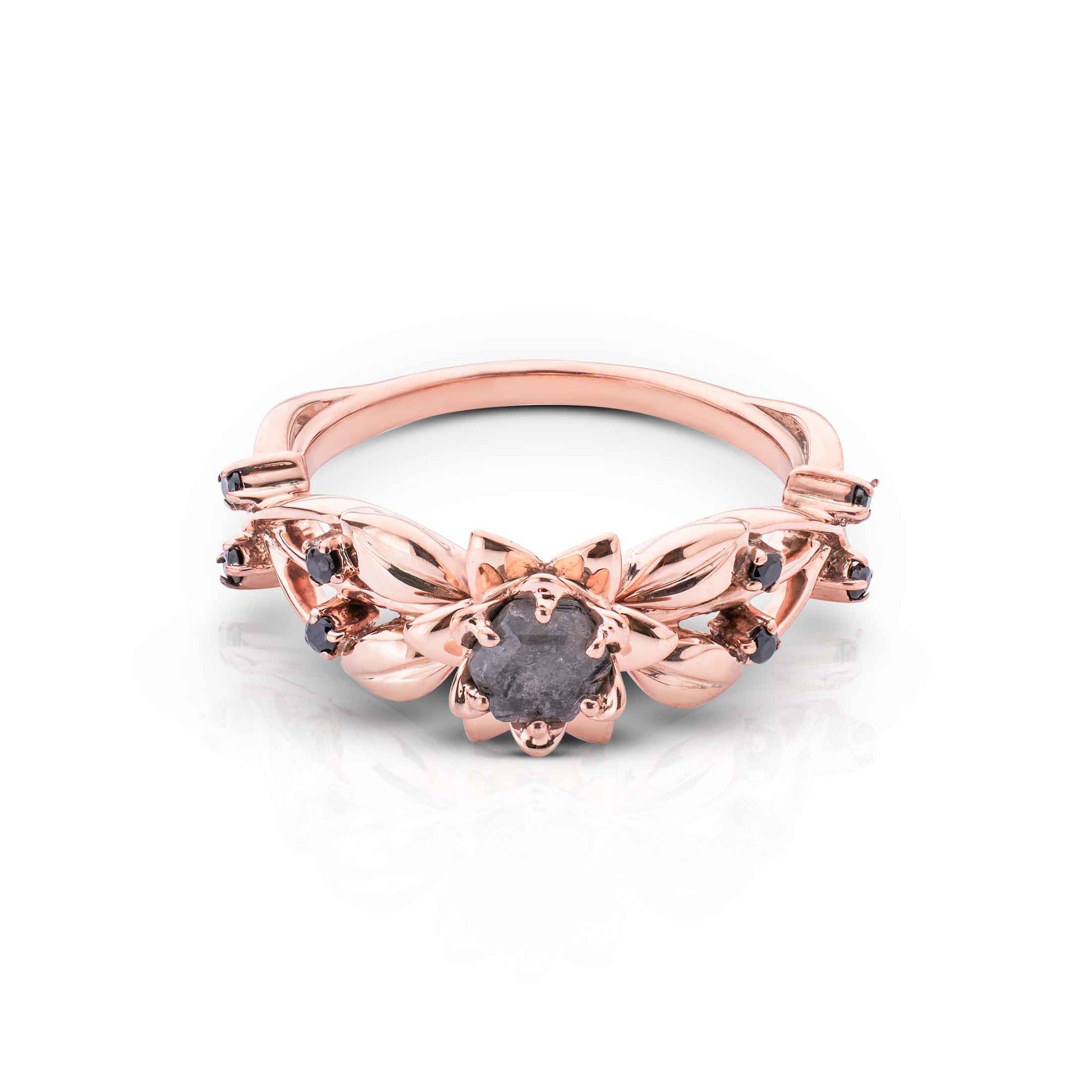 Floral rose gold band featuring a dark, rough-cut center gem and small black stones on the leaves.