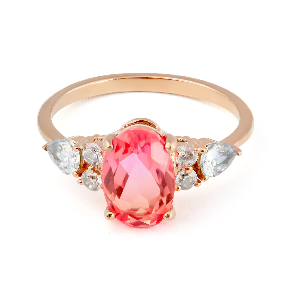 Oval-cut pink sapphire ring in rose gold with pear and round diamond-style side stones.