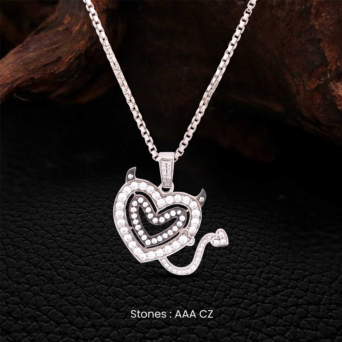 Silver necklace with a heart-shaped pendant on a dark textured background