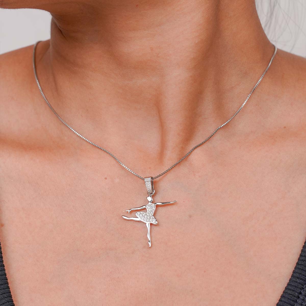 minimalist necklace with a silver ballerina pendant on a person's neck