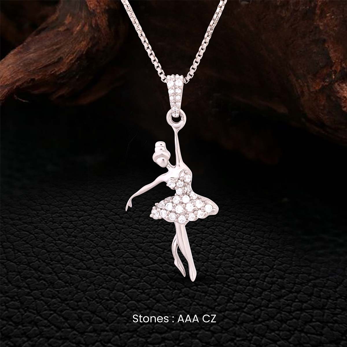 Silver ballerina pendant necklace on a dark textured background