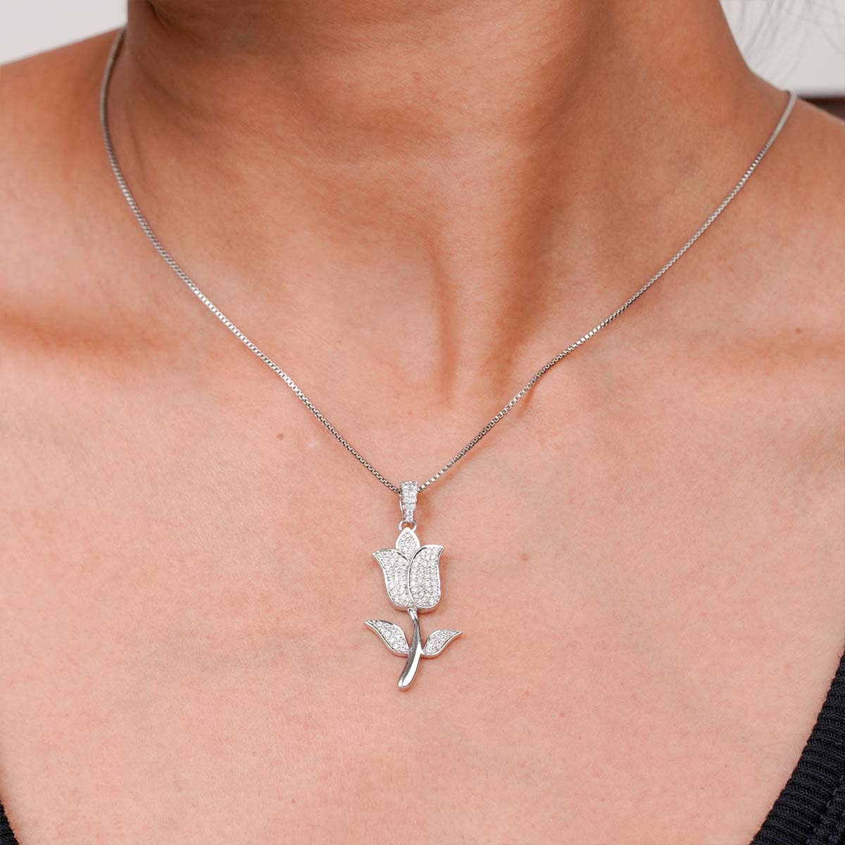 iced out tulip pendant necklace on a person's neck