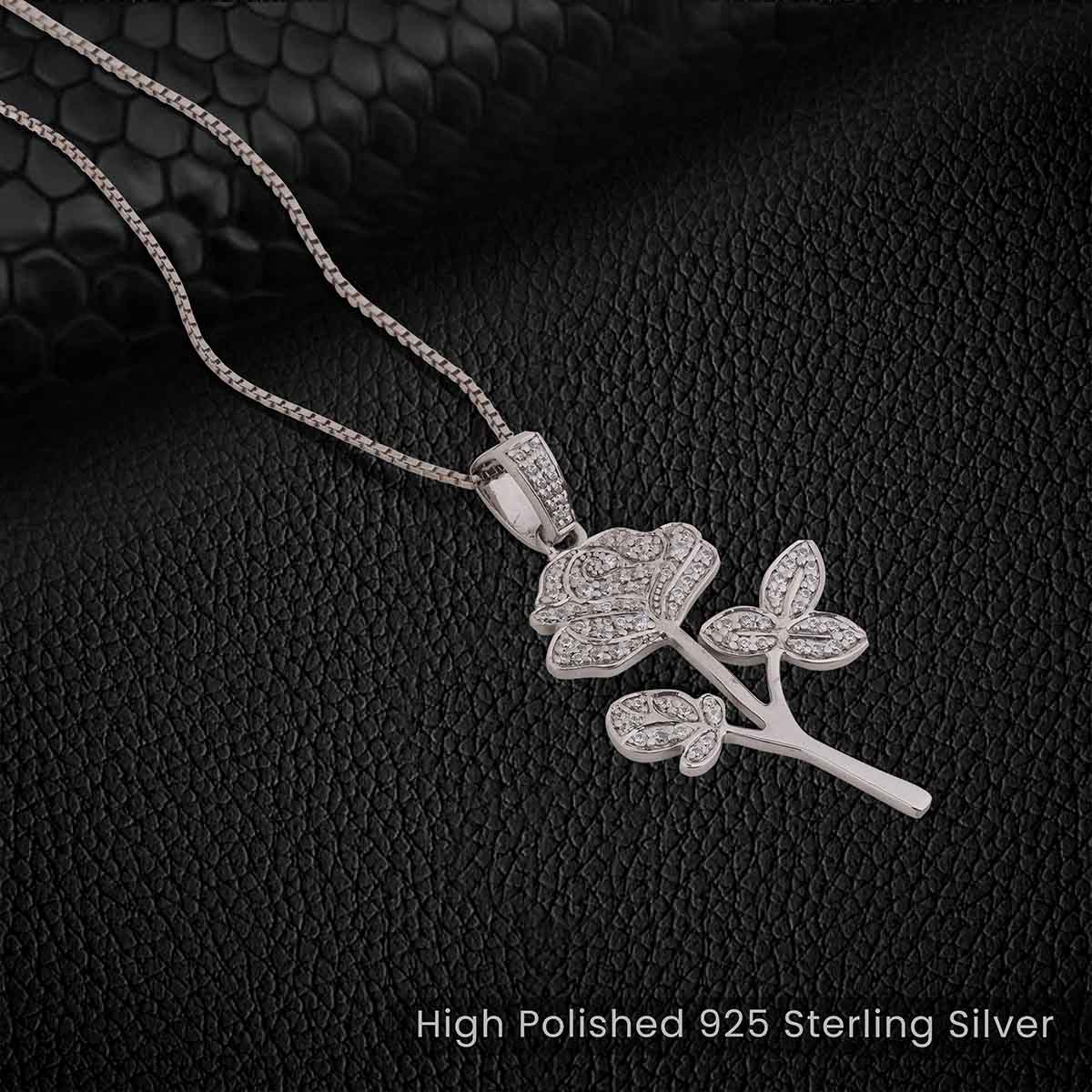 Sterling Silver rose flower pendant necklace on a black textured background