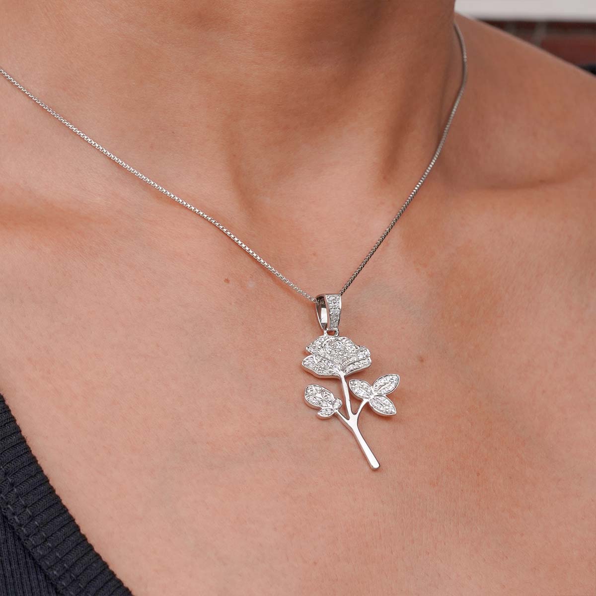 rose-shaped pendant necklace on a person's neck