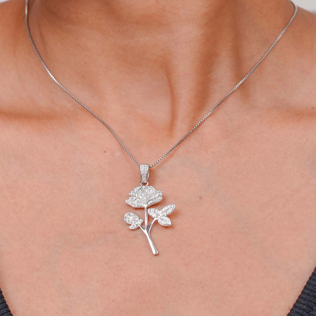 Sterling Silver rose-shaped Flower pendant necklace on a person's neck 