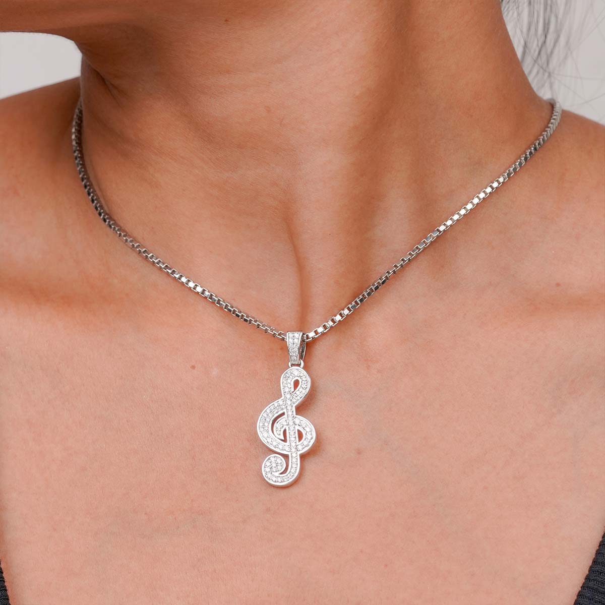 Sterling Silver treble clef pendant Music Note necklace on a person's neck