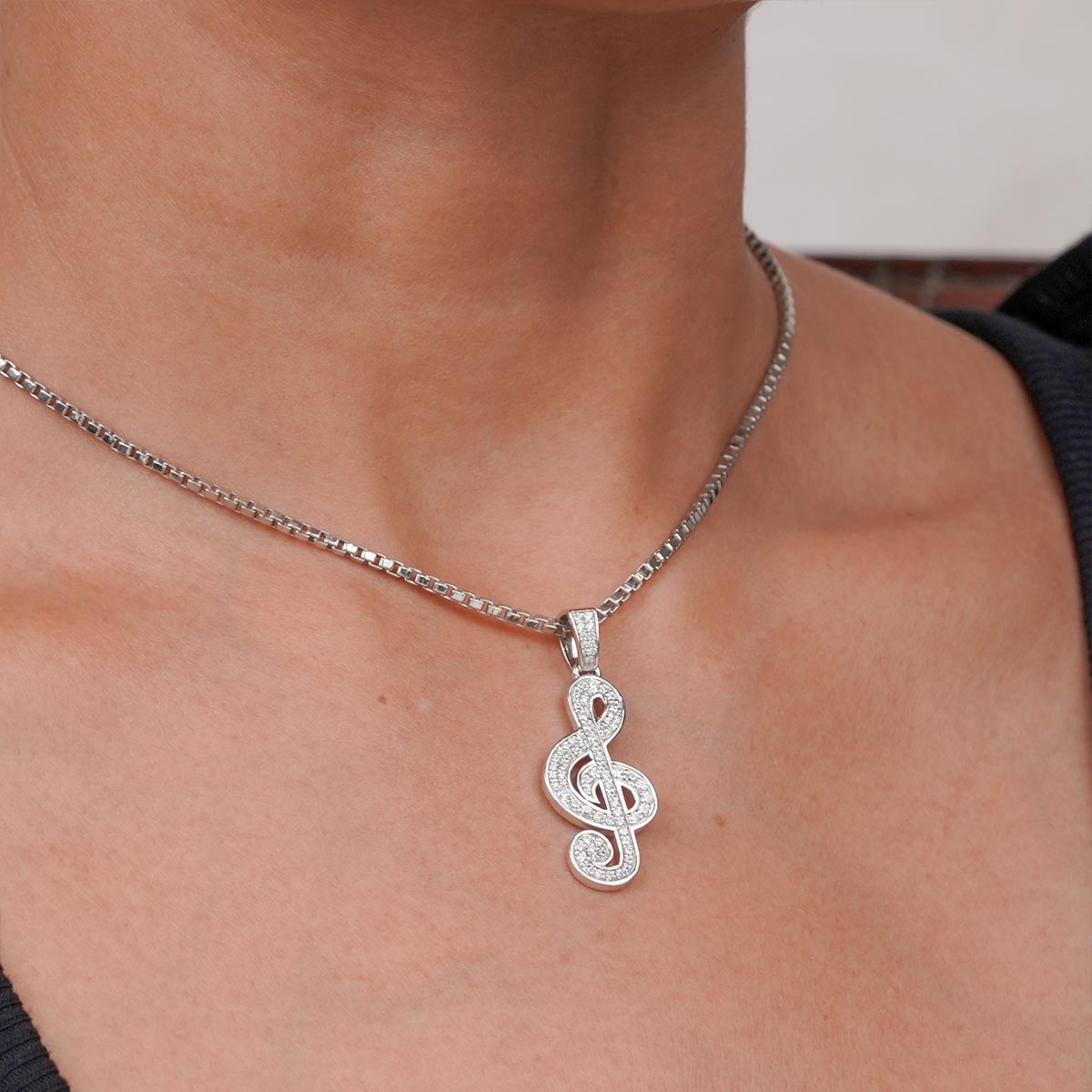 Sterling Silver treble clef pendant Music Note necklace on a person's neck