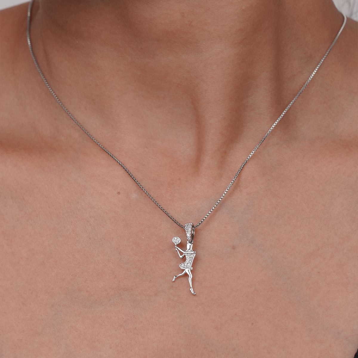 Silver tennis player pendant necklace on a girl's neck