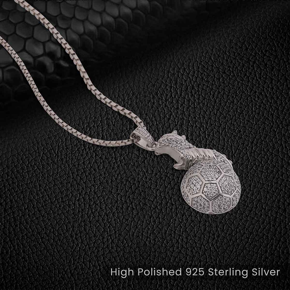 Silver pendant with a soccer ball design on a black textured background