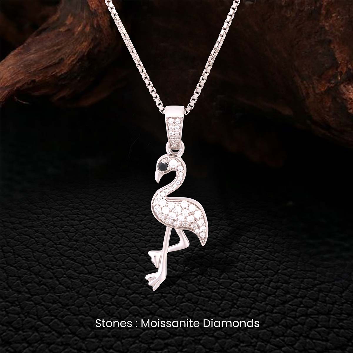 Sterling Silver flamingo pendant necklace with moissanite diamonds on a dark textured background