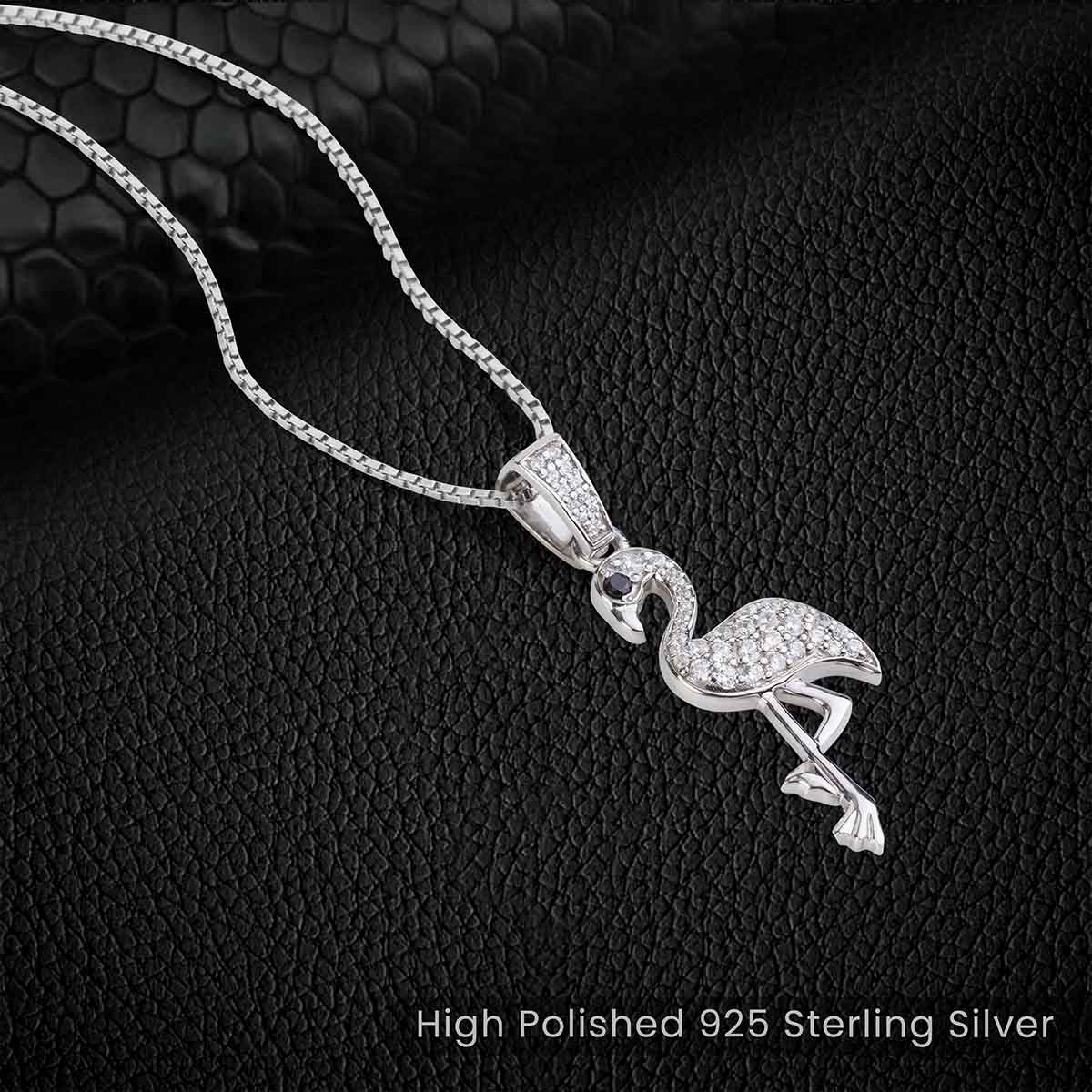 Flamingo-shaped silver pendant necklace with box chain on a black textured background