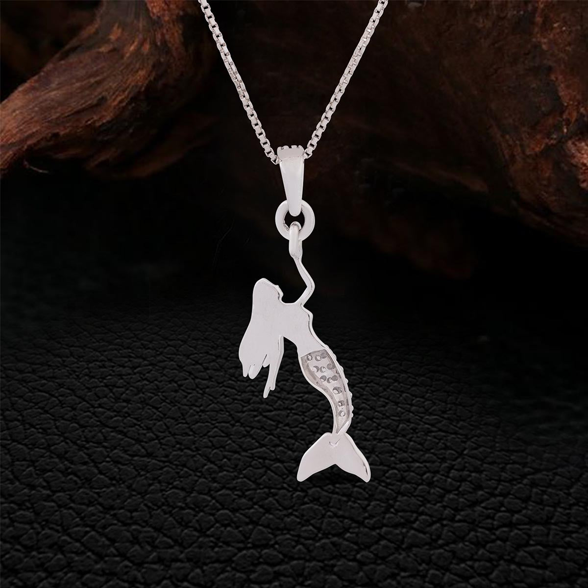 Backside of Sterling Silver mermaid pendant necklace on a dark textured background