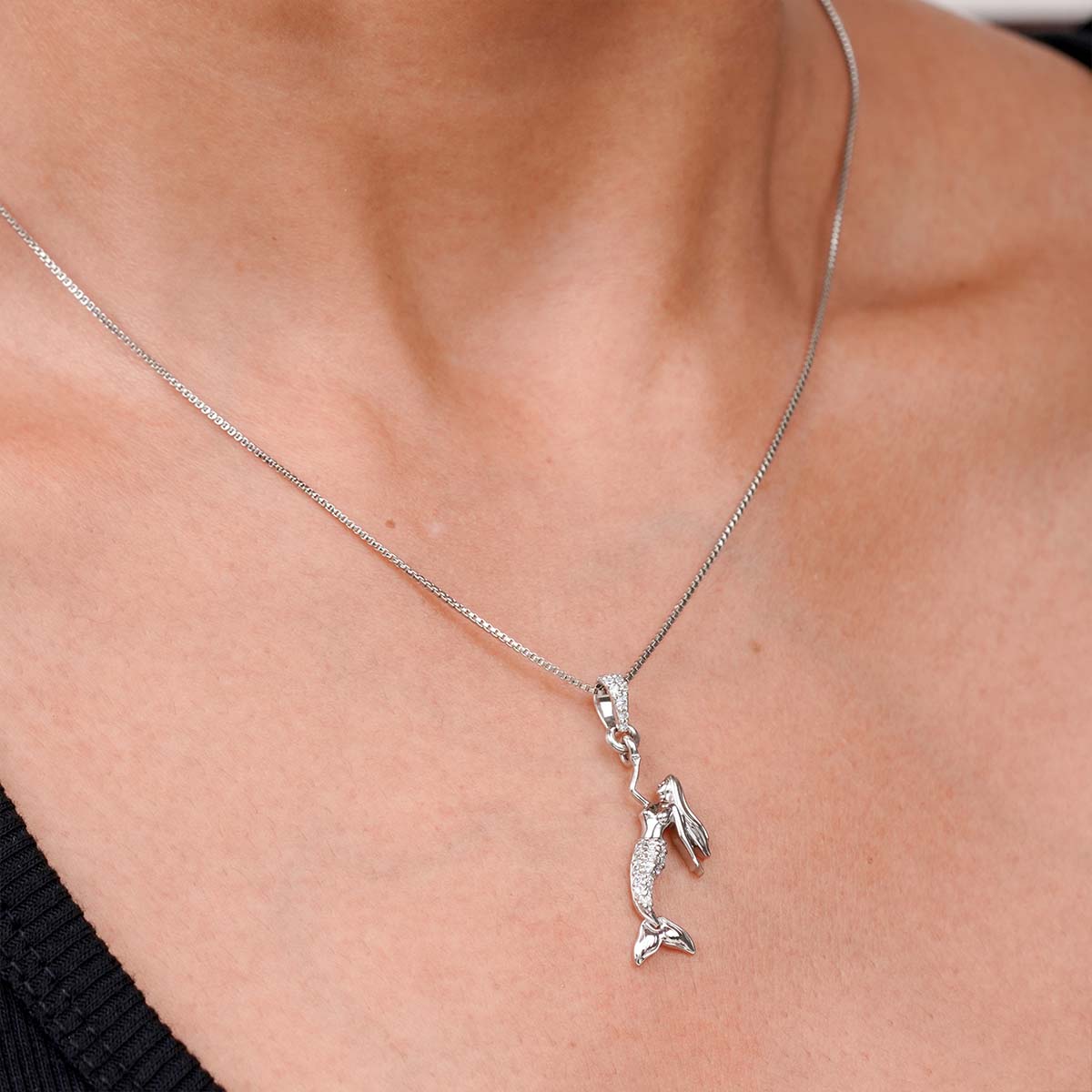 Minimalist mermaid Sterling silver pendant necklace on a person's neck