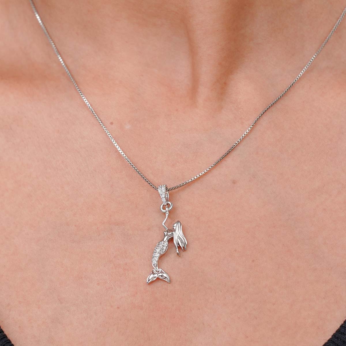Minimalist mermaid Sterling silver pendant necklace on a person's neck