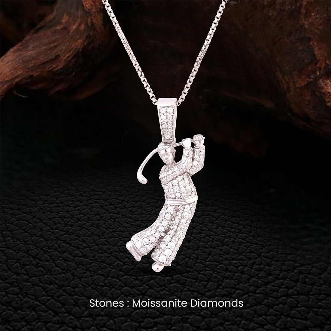 Silver golfer pendant necklace with moissanite diamonds on a dark textured background