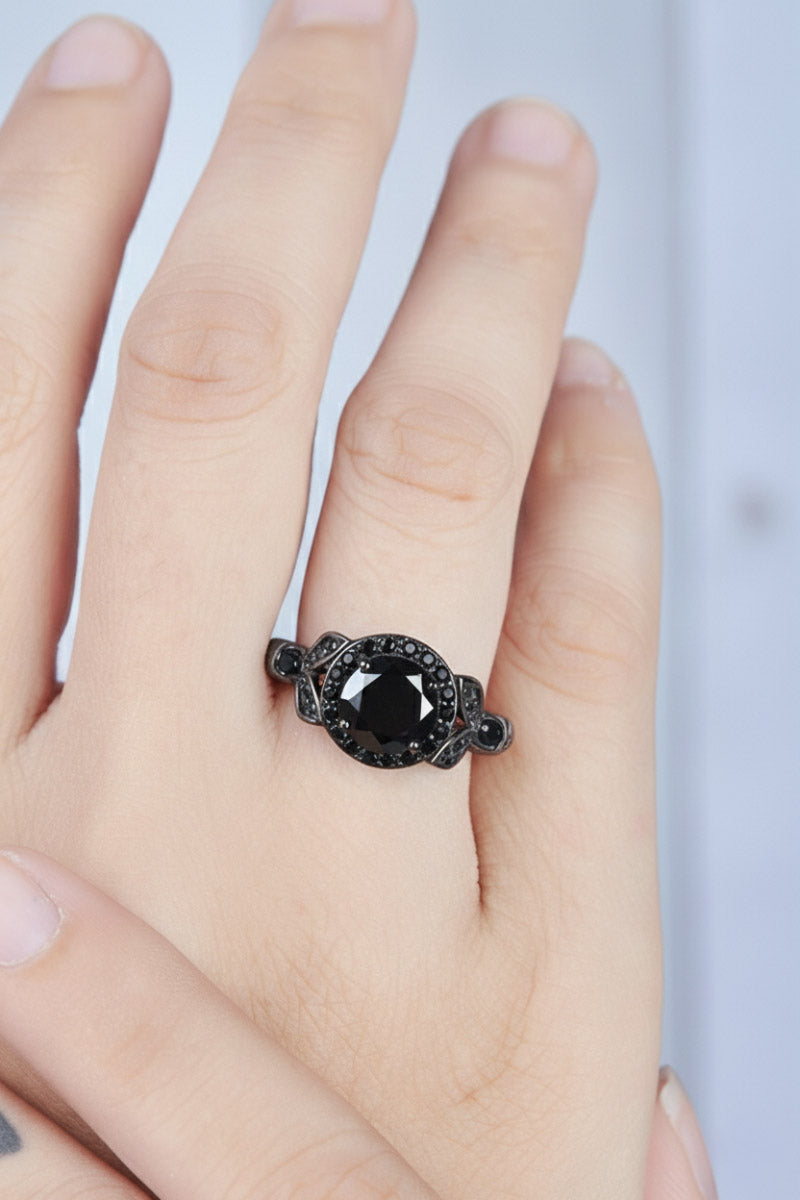 Black skull ring with halo leaf design on a woman's finger