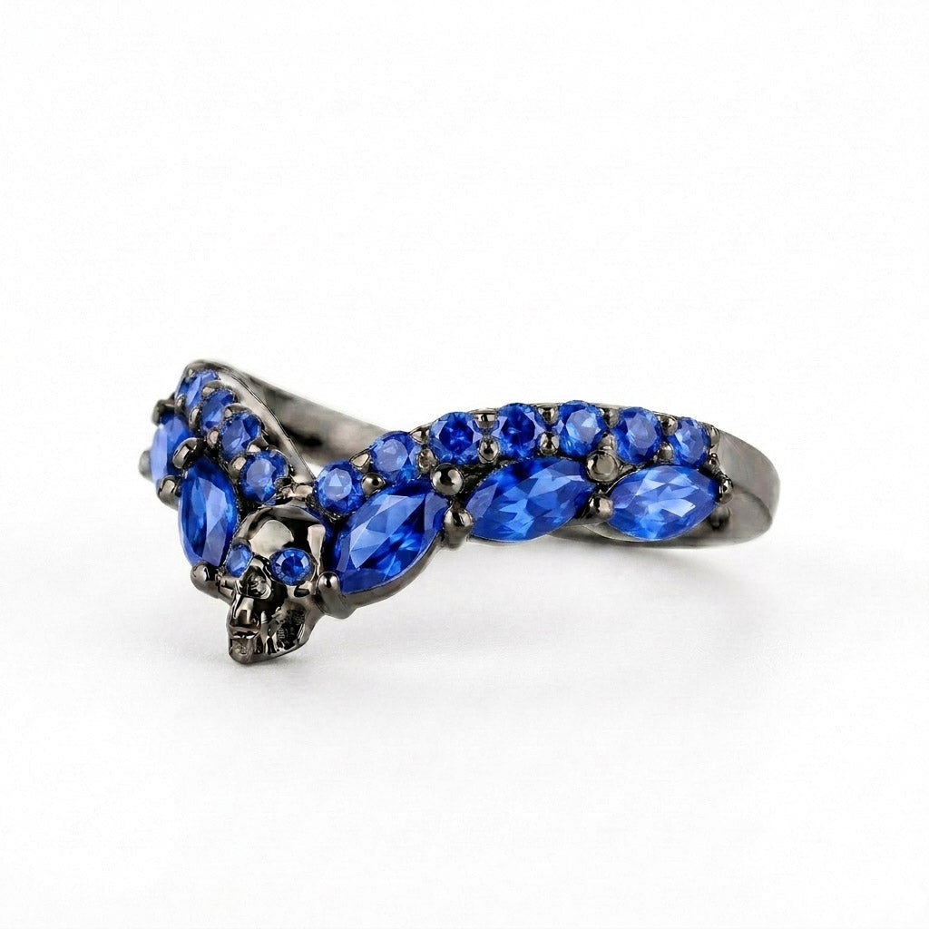 Gothic chevron stacking ring with a detailed skull center and blue sapphire cubic zirconia gemstones