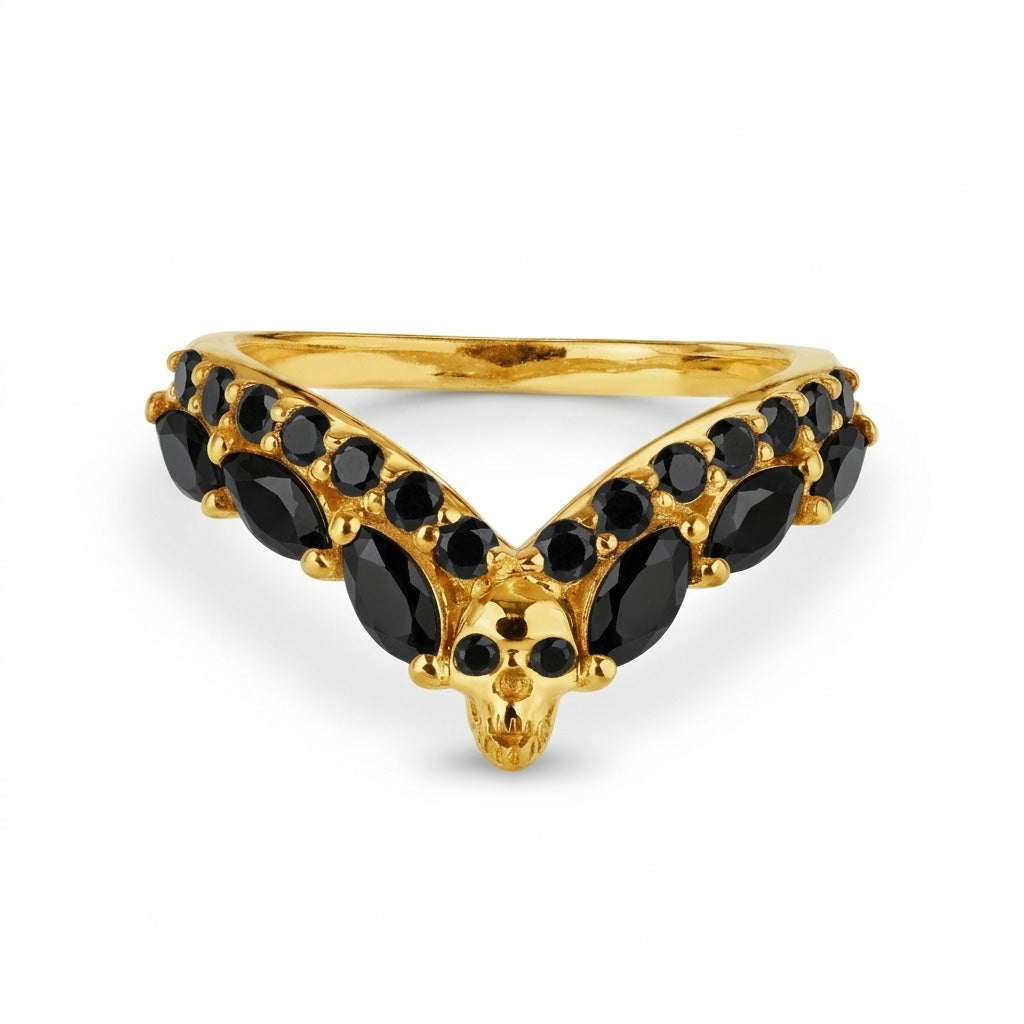 Bold yellow gold skull wedding band with black onyx gemstones, a unique V-shaped chevron ring enhancer for a striking gothic jewelry aesthetic.