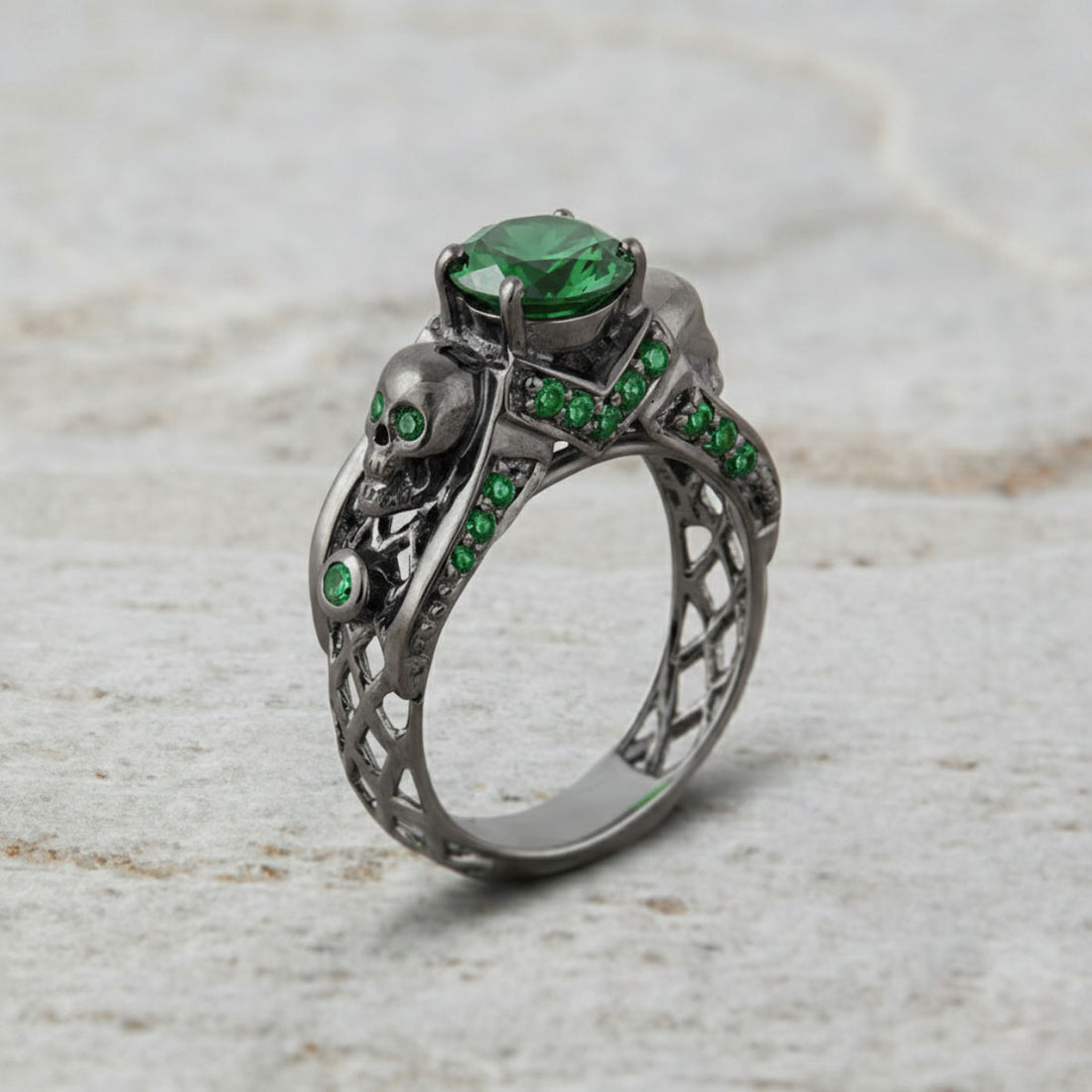 black skull ring with green emerald gemstones and criss cross mesh design band
