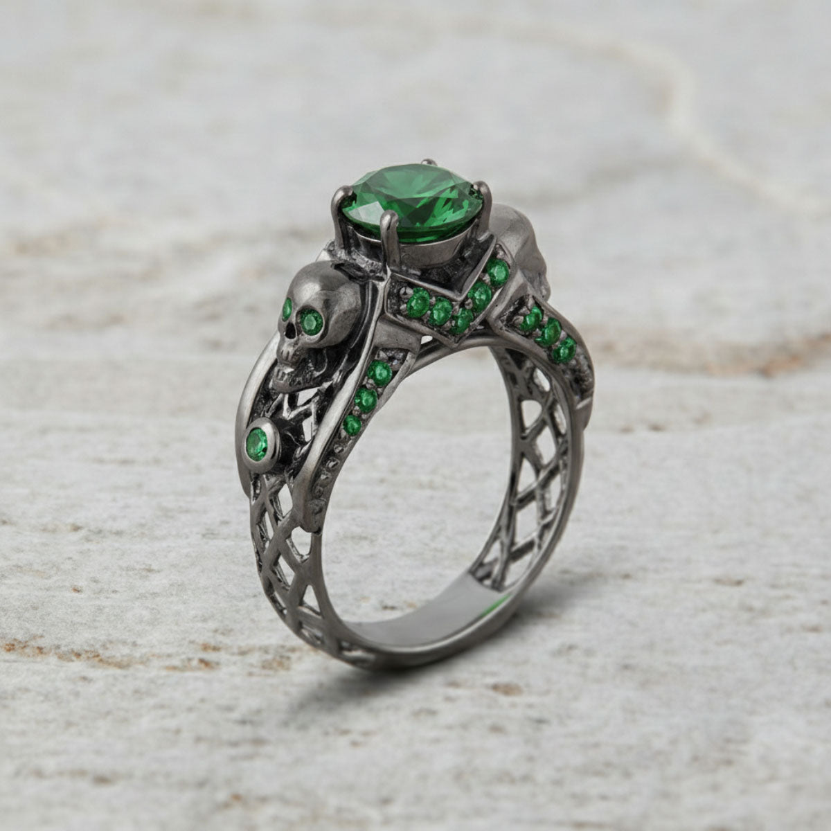black skull ring with green emerald gemstones and criss cross mesh design band