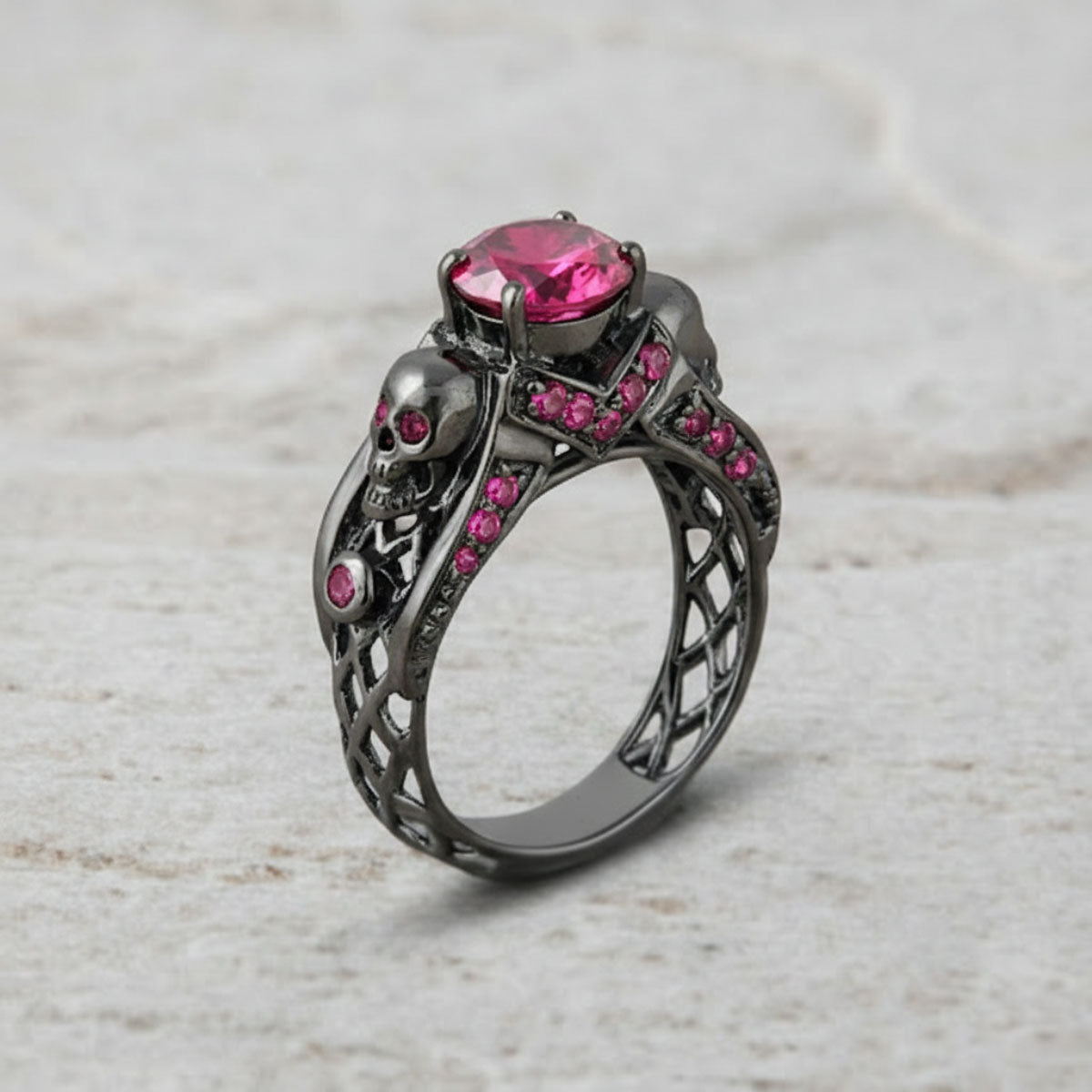 black skull ring with pink ruby gemstones and criss cross mesh design band