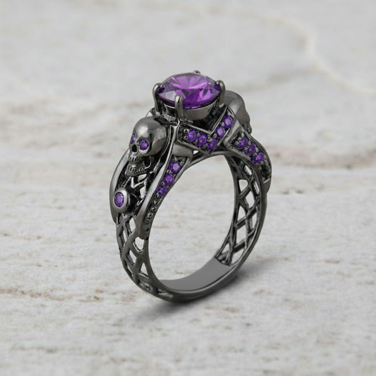 black skull ring with purple amethyst gemstones and criss cross mesh design band