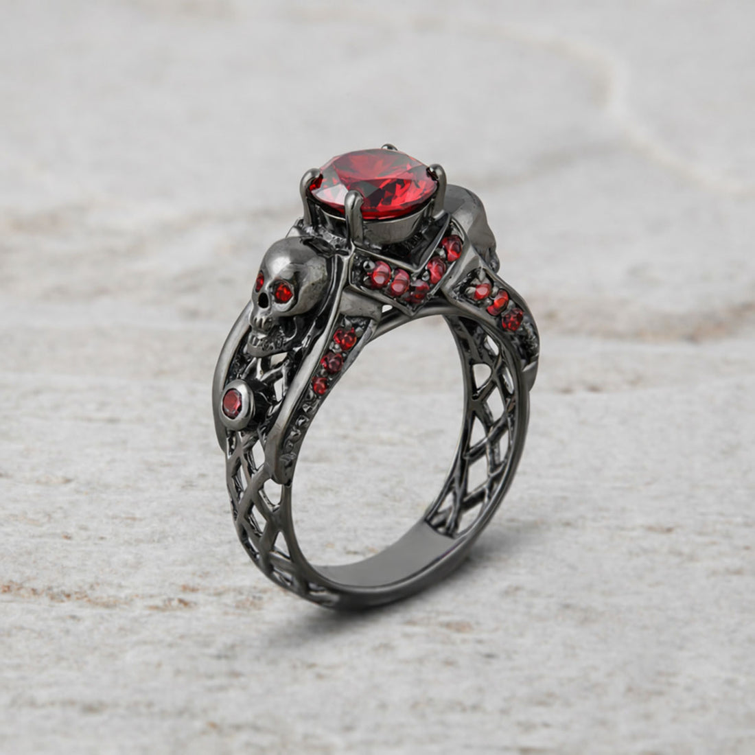 black skull ring with red garnet gemstones and criss cross mesh design band