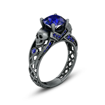 black skull ring with blue sapphire gemstones and criss cross mesh design band