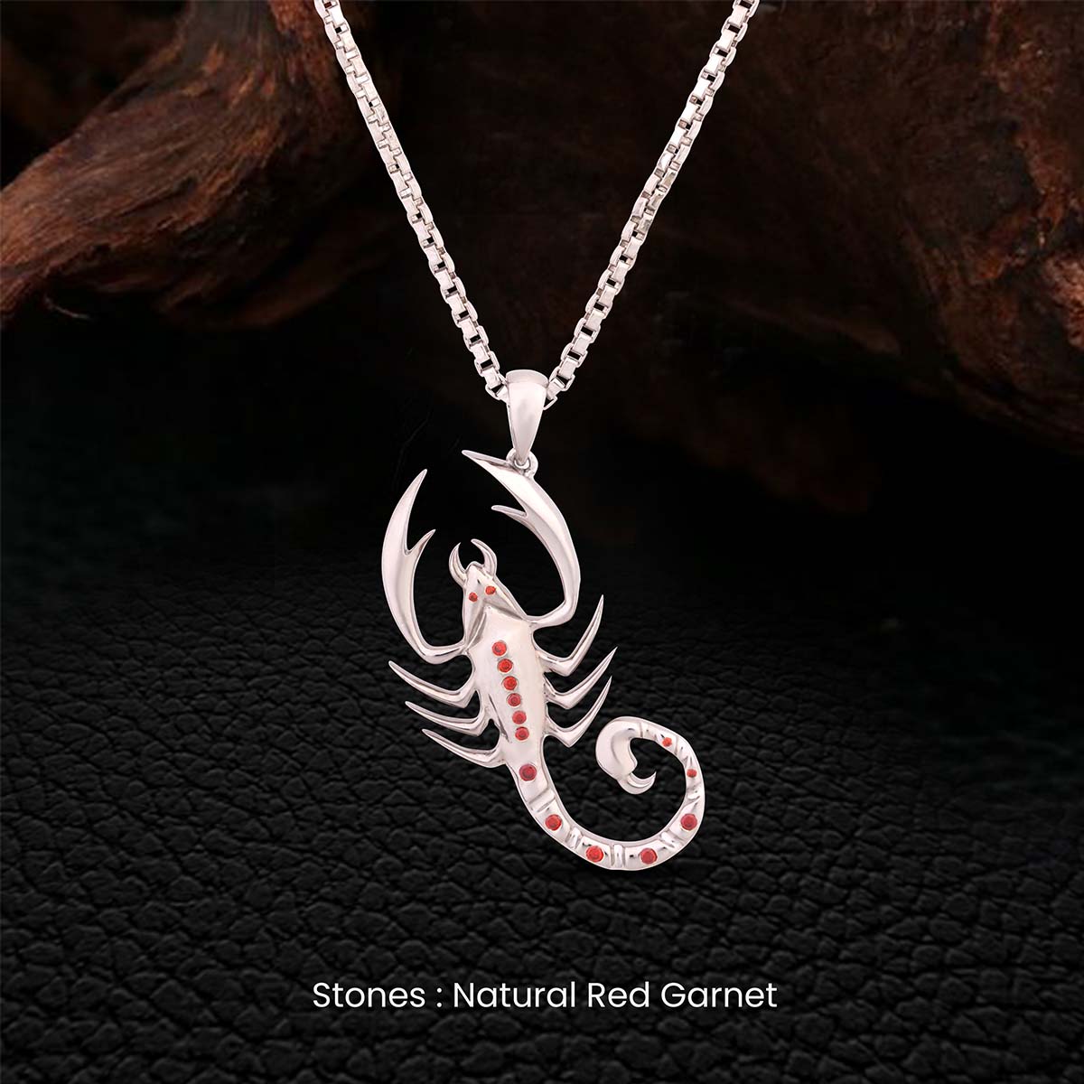 Sterling Silver scorpion pendant necklace with red natural garnet stones on a dark textured background