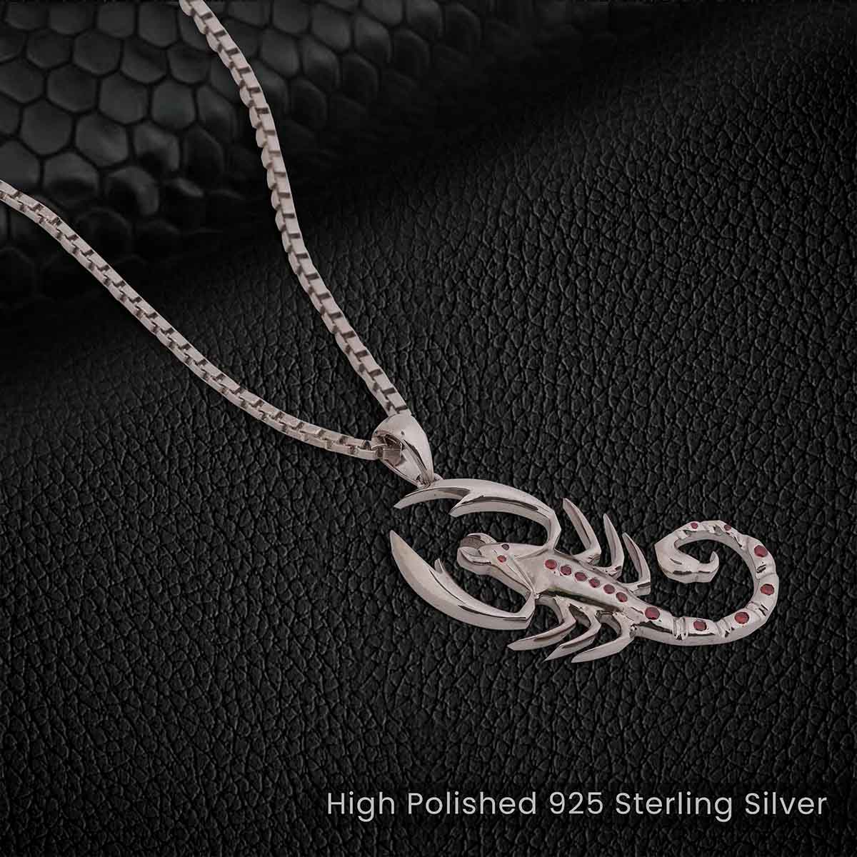 Silver scorpion pendant necklace on a textured black background