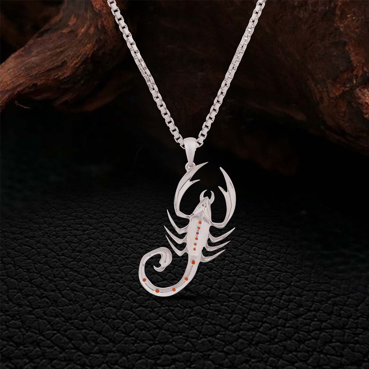 Backside of Sterling Silver scorpion pendant necklace on a dark textured background