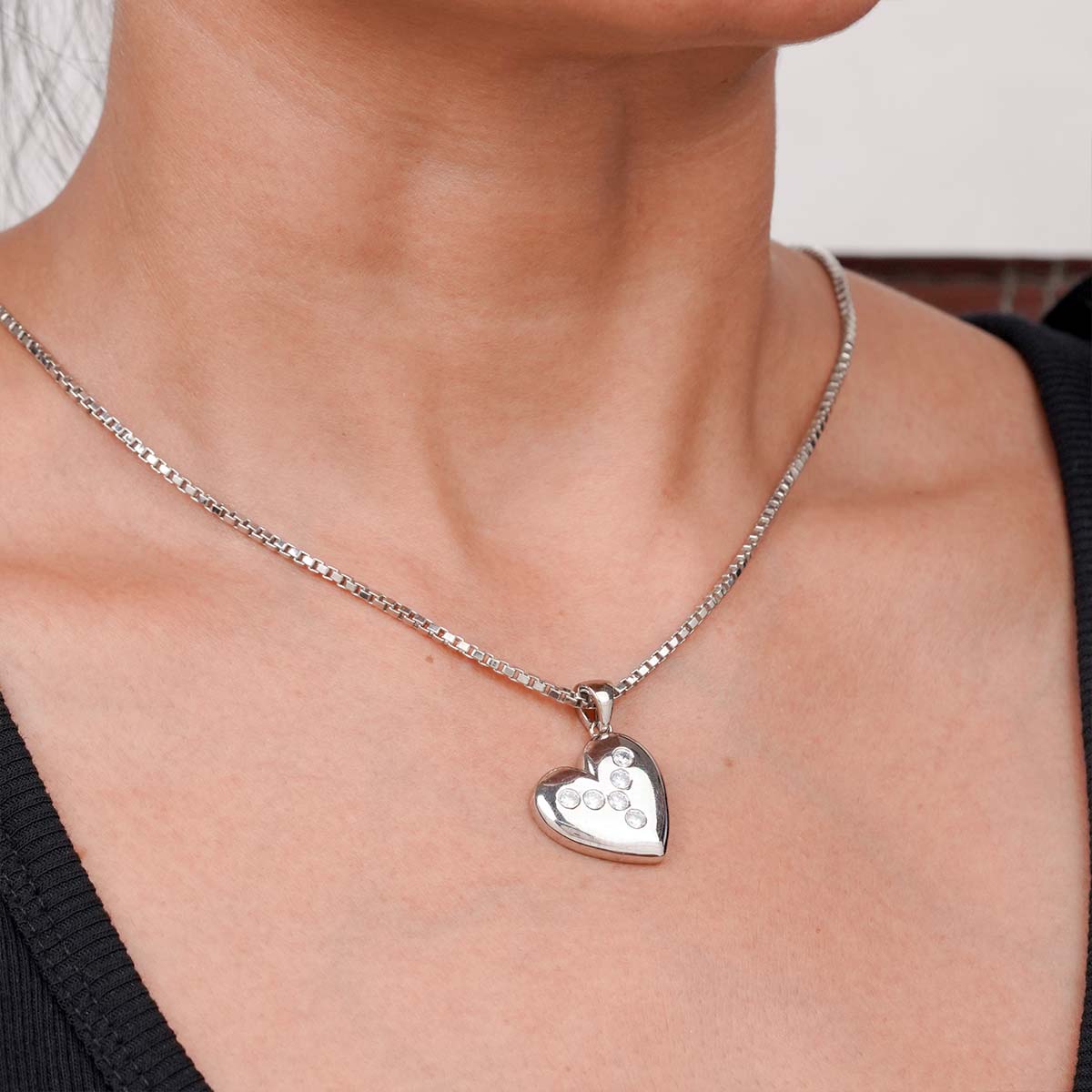 Sterling Silver heart-shaped pendant necklace on a person's neck