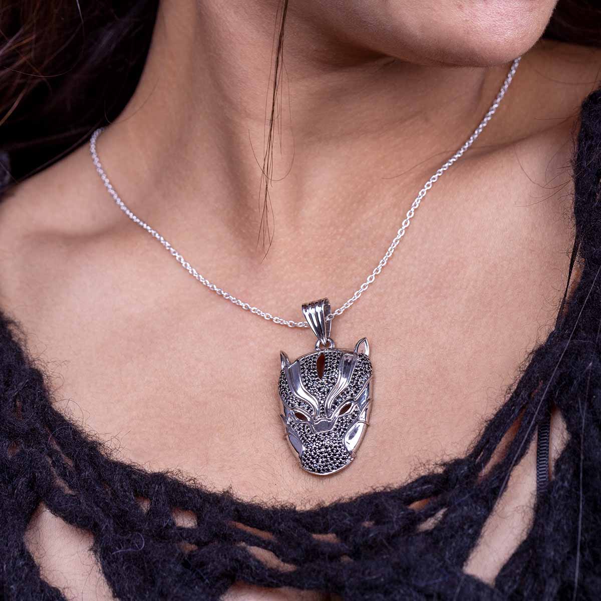 Silver panther pendant necklace on a person wearing a black lace top.