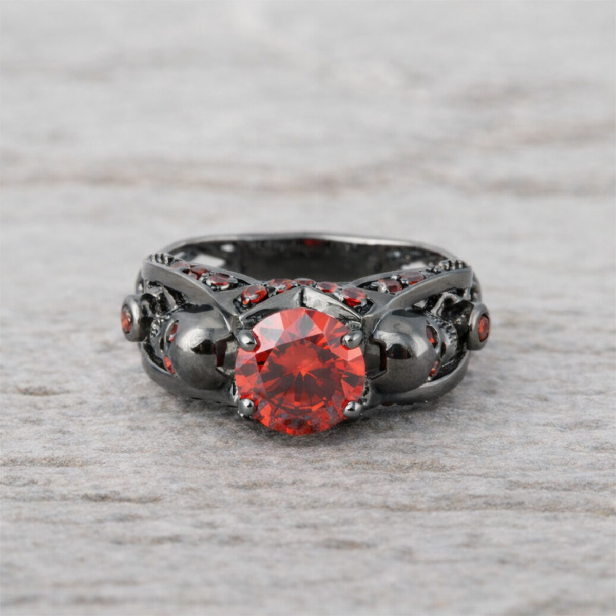 black skull ring with red garnet gemstones and criss cross mesh design band
