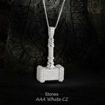 Silver pendant shaped like a hammer with clear stones on a dark background