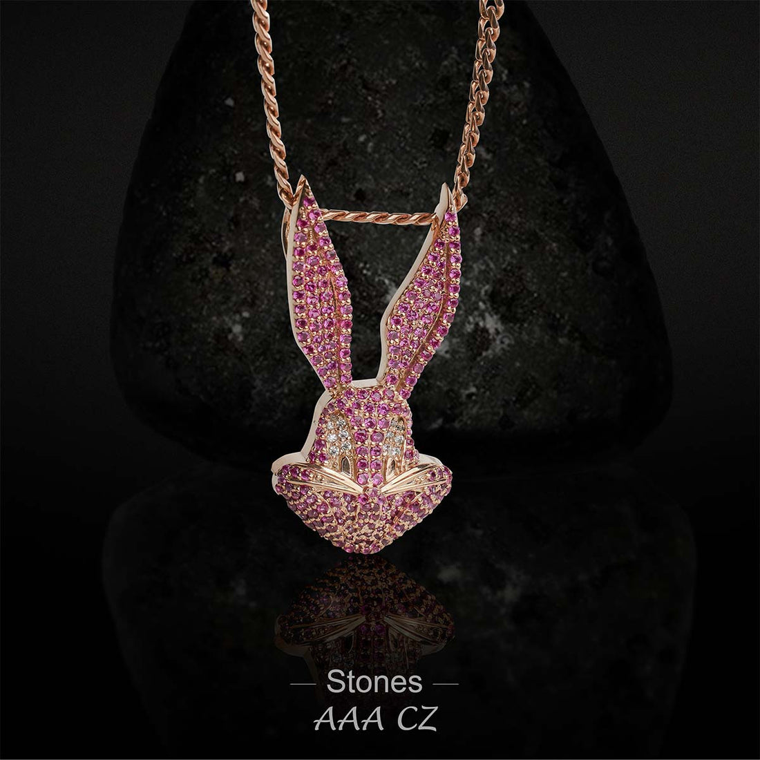 Rose gold bunny pendant with pink stones on a dark background
