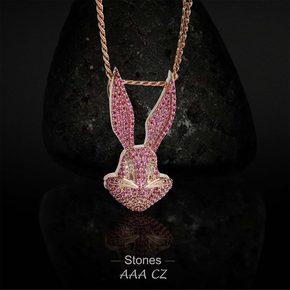 Rose gold bunny pendant with pink stones on a dark background