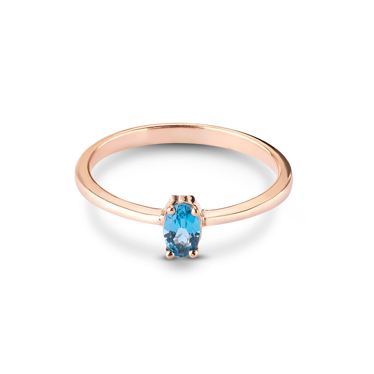 Delicate rose gold solitaire ring featuring a small, vibrant oval-cut blue topaz gemstone.