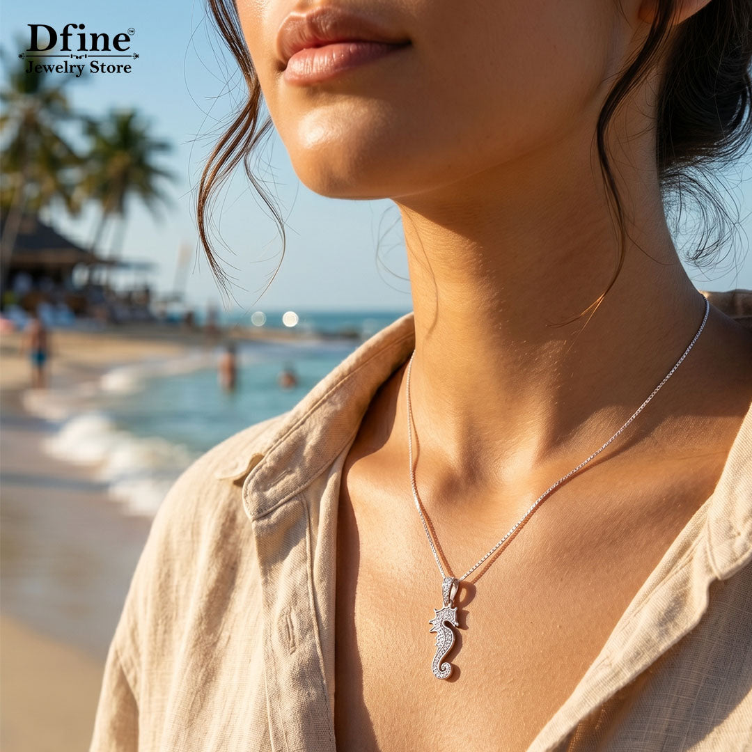 silver iced seahorse pendant necklace wearing by a woman on a beach.