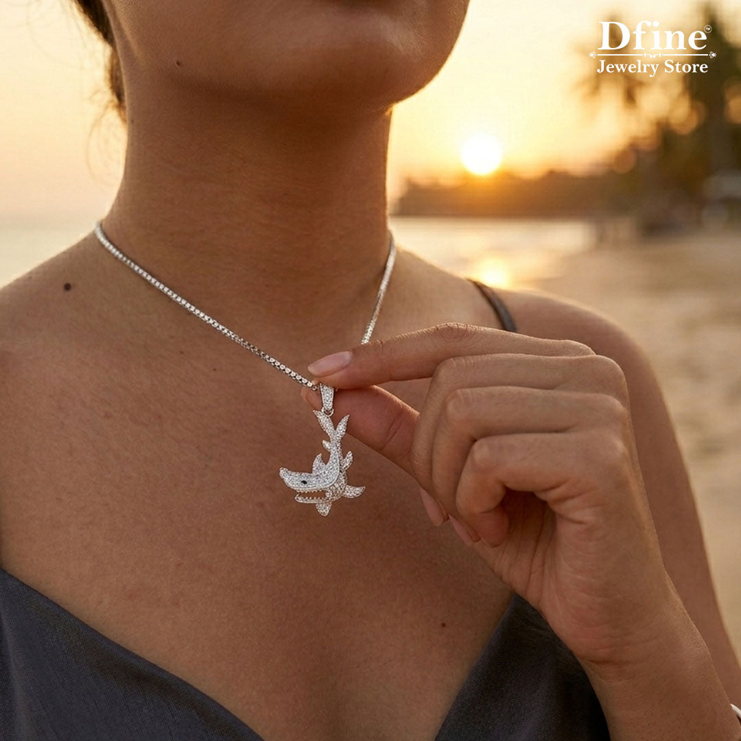 woman holding a sterling silver iced out shank pendant necklace against a sunset background, with Dfine Jewelry Store branding.